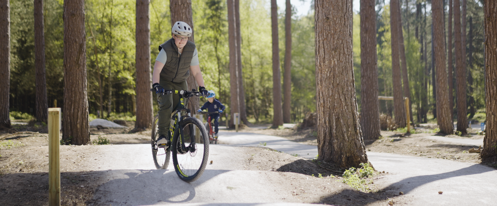 Boy standing up on his bike to go over some bumps on a cycle trail