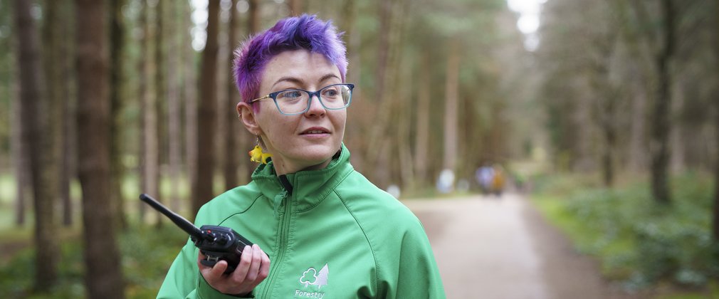 woman with short purple hair working in a forest