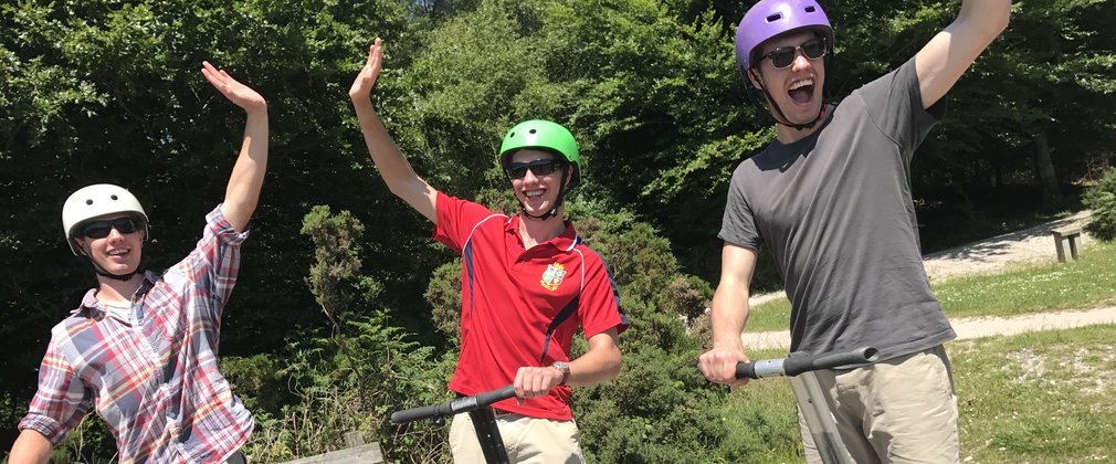 Three guys enjoying Segway in the forest 