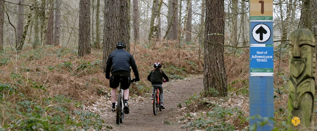Father and daughter riding bikes on the blue adventure trail