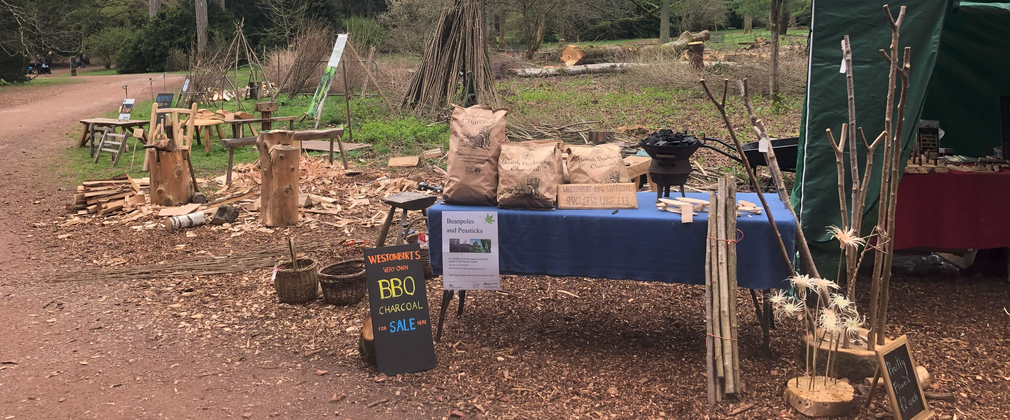 A table with a blue cloth has been covered in coppice products ready to sell.