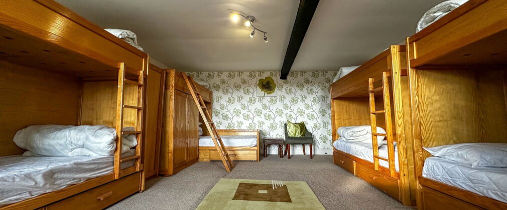 A bunk room with a grey carpet and sage rug