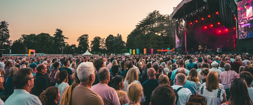 An outdoor concert stage with crowd at dusk