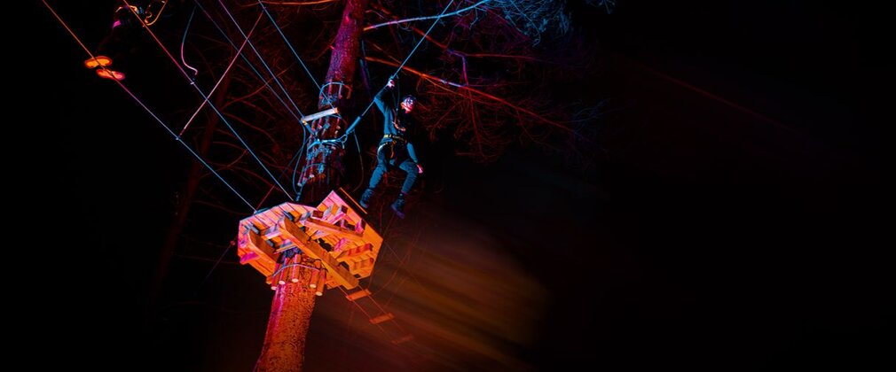 A Go ape participant gets ready to jump off the zip wire during a colourful sundown session