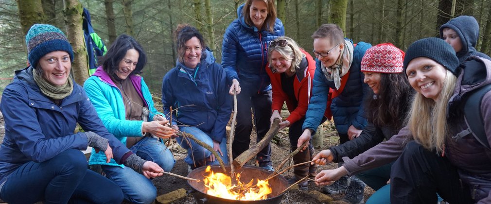 Wild women days women round campfire in the forest 