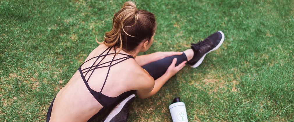 Woman exercising outside on green grass