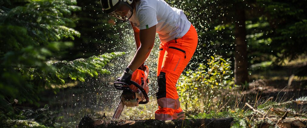 Woman with chainsaw in forest