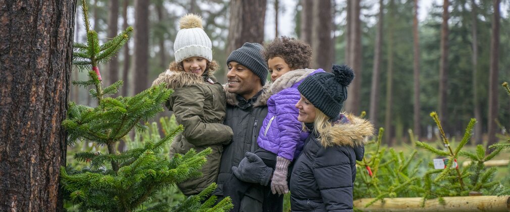 Family standing with christmas tree
