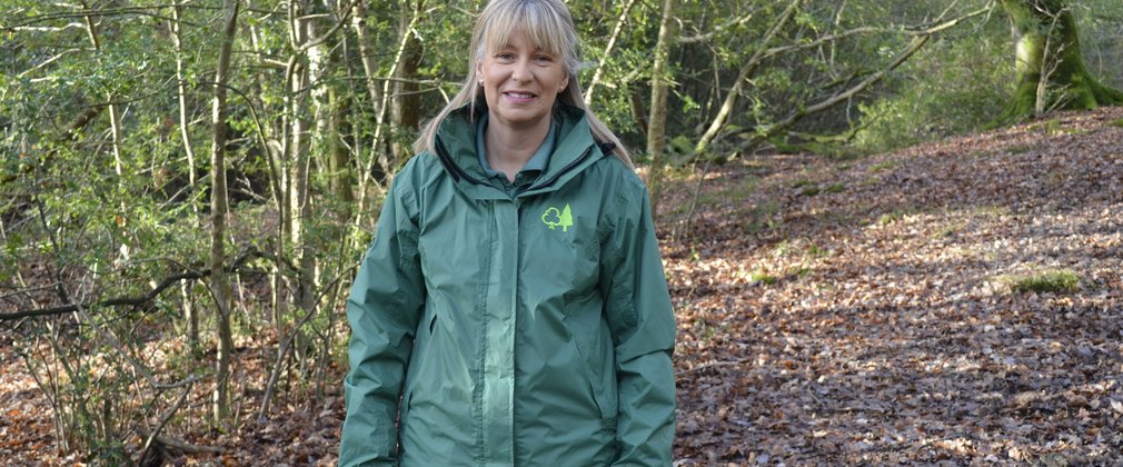Jane, a volunteer ranger stand in a autumnal woodland