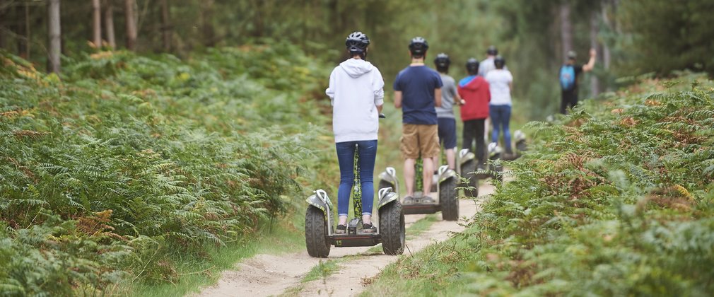 people on Segways on a forest path