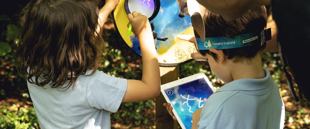 Two boys interact with UV sign and iPad