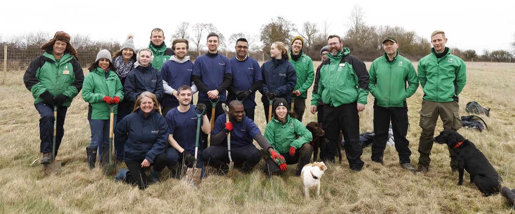group of people with 2 dogs in a field