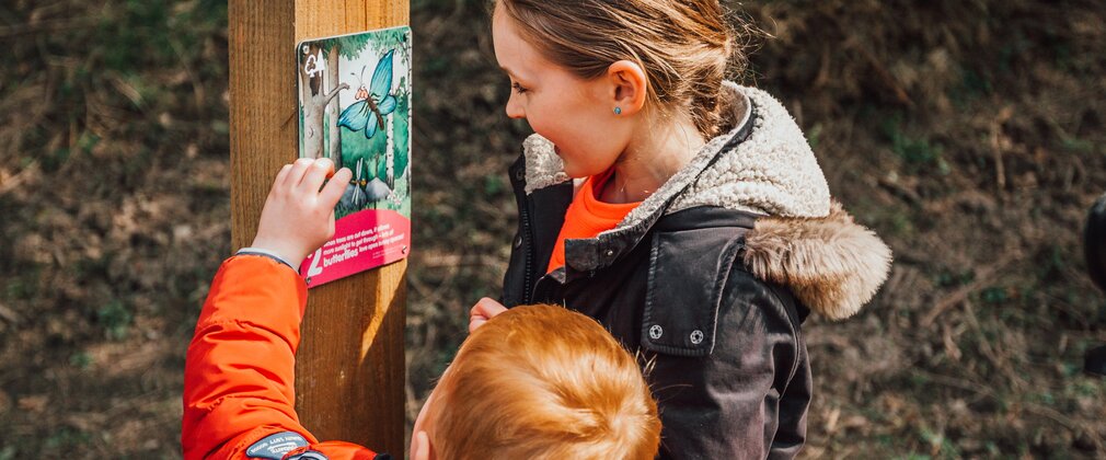 Two children interacting with a Gruffalo Orienteering post