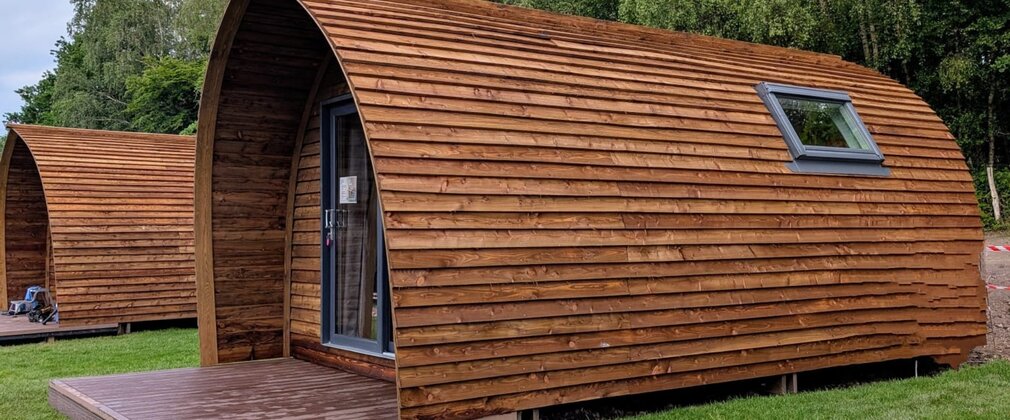 Large wooden glamping pod with door to the front and window on side