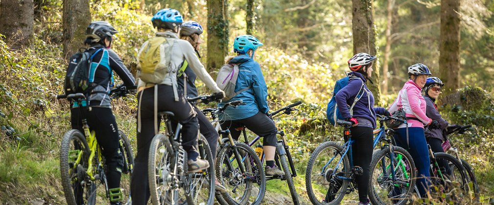 group of ladies on mountain bikes in a forest