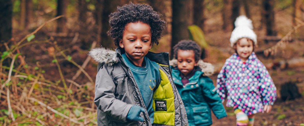 Young children running in the forest