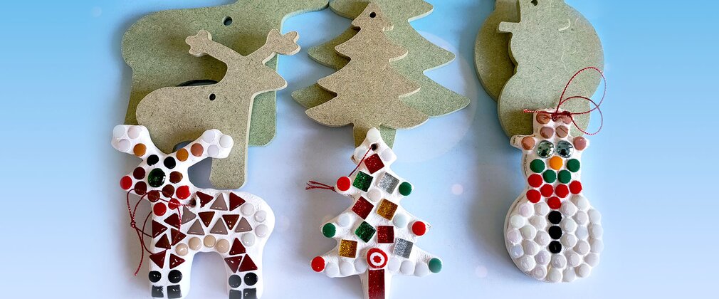 A collection of hand made Christmas decorations featuring a reindeer, Christmas tree and a snowman, with colourful glass mosaic decorations/