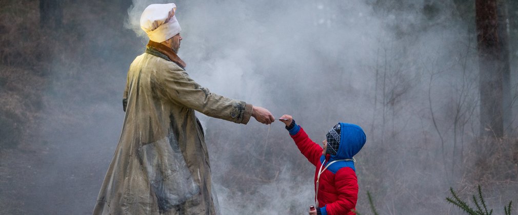 Theatrical figures reaching out a hand to a child