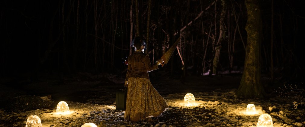 Theatrical person in a ring of light in a forest