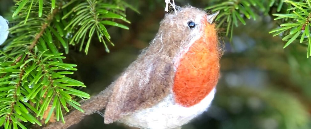 A felt robin hanging on a tree