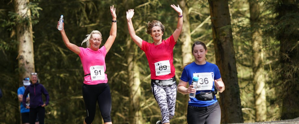 Women running in the forest at an organised event