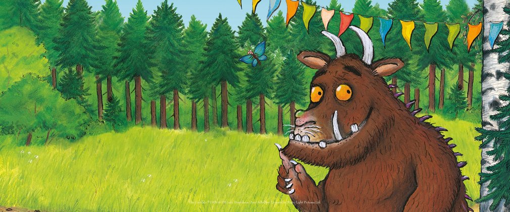 A digital illustration of the Gruffalo standing in the forest with bunting strung above him.