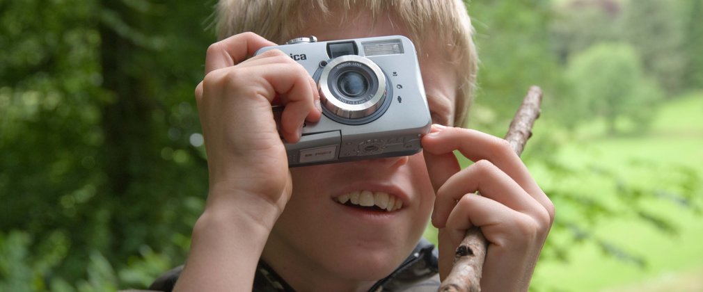 Child with camera in the forest 