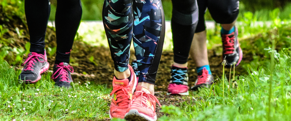 Legs of four runners wearing pink trainers