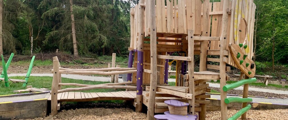 Wooden play area in a forest setting.