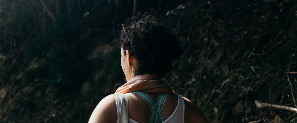 Brunette woman looks away from camera in the forest