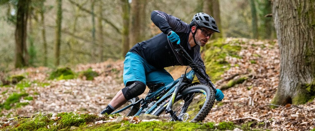 A man on a mountain bike in the forest.