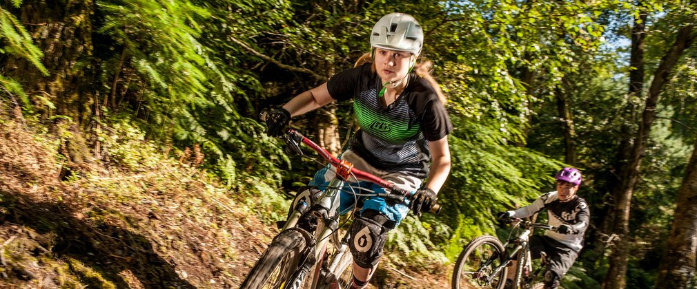 Rider on Mountain Bike through trails in the woods 