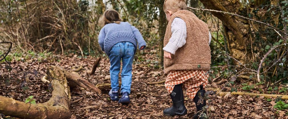 two small children exploring woodland