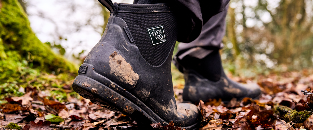 close up of muddy boots walking through forest