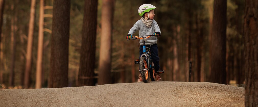 boy rides bike on pump track