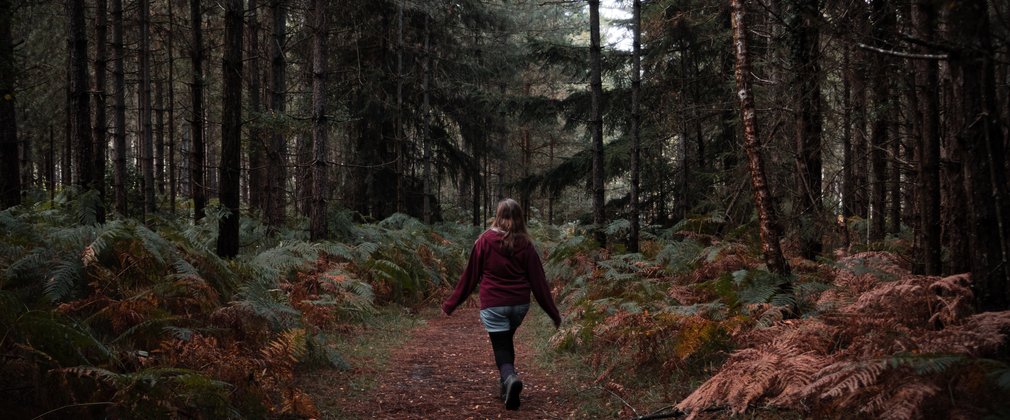Woman walking through woodlands