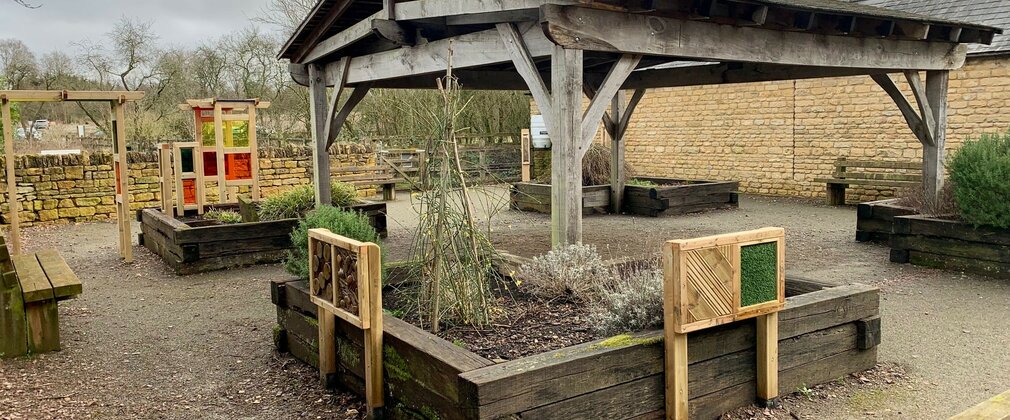Raised beds and sensory play elements in a courtyard