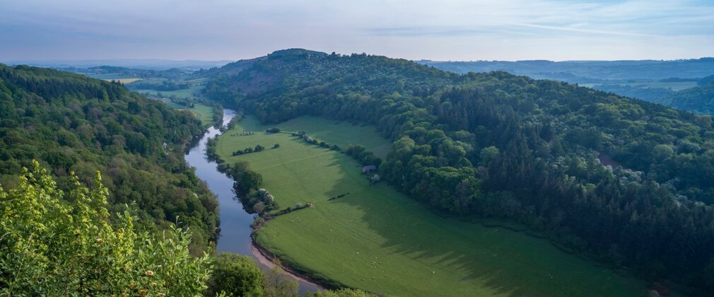 Looking down to a river winding through lush green landscape.