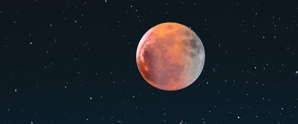 A red tinted moon in a starry sky