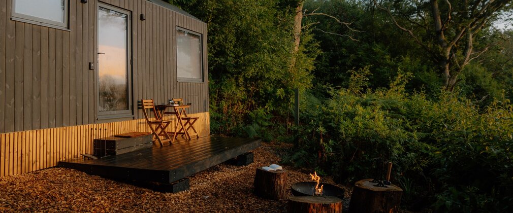 Cabin in a forest with chairs outside