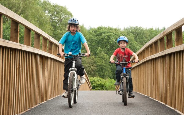 two boys cycling in the forest on a cycle route