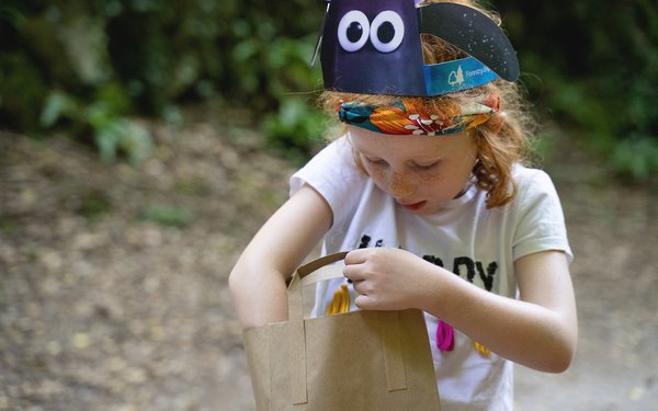 Young girl in shaun ears reaches into pack