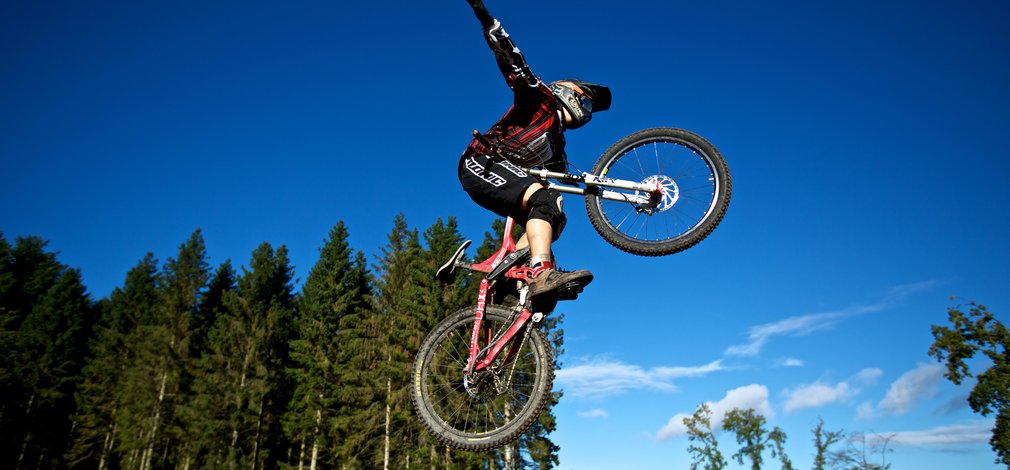 Mountain Biker doing jump and stunts in the forest