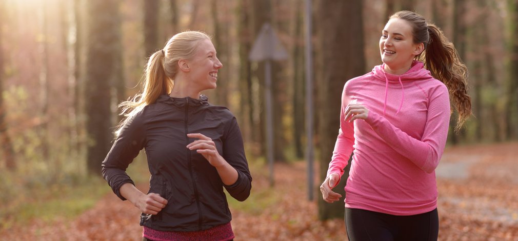 running generic adults on a run on a woodland trail