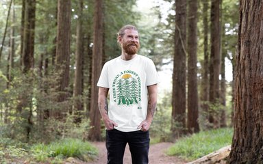 Happy bearded map in white t-shirt in a forest