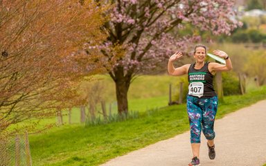 Forestry 100 Running Series, woman finishing race at Bedgebury