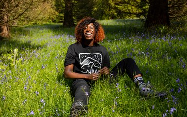 Women sat on the forest floor smiling to camera