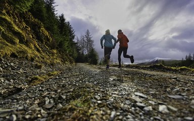 Two people running uphill