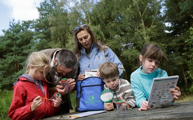 A family looking into their Forest Activity Bag at Sherwood Pines