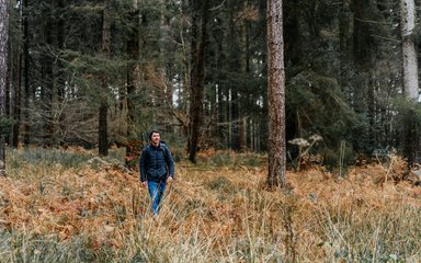 A man walking through a forest clearing